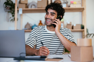 Cheerful Hispanic employee speaking with client and making notes