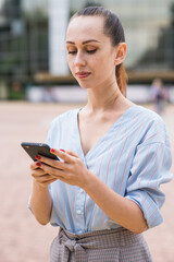 Portrait of attractive and beautiful Caucasian business woman. Lady is using a smartphone. Business and networking concept.