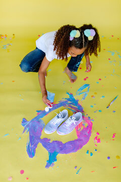 Overhead shot of girl with tube paint