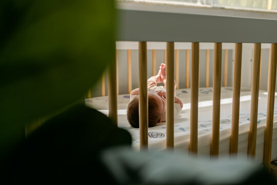 Baby laying alone in his crib