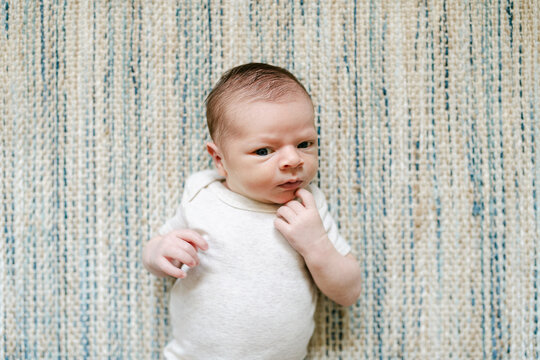 Newborn laying on green rug