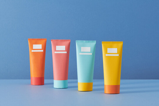 Minimal packages design. Four cosmetic tubes on blue