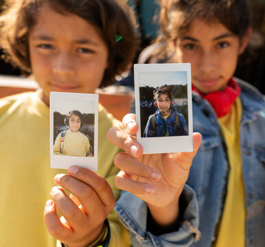 Kids showing at camera their instant photo