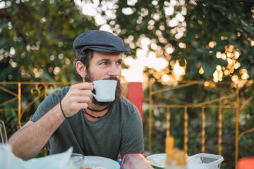 Man drinking hot beverage in outdoor cafe