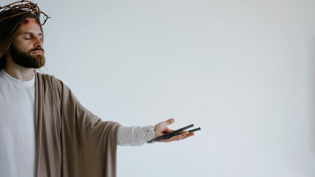 Jesus' hand with stigma holds a crucifixion nail on a white background. Studio. High quality 4k footage