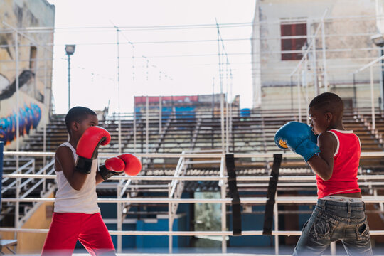 Teenagers in boxing gloves fighting on ring