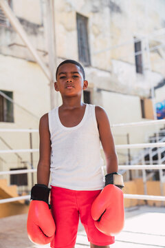 Teenager in boxing gloves and sportswear on ring
