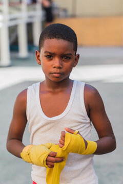 Young kid putting bandages on hands.