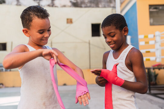 Smiling teenagers bandaging elastic bandage on hands