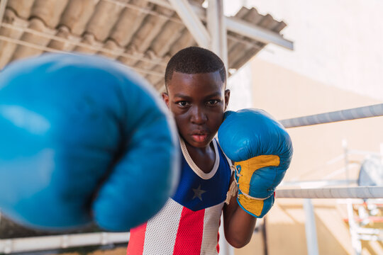 Teenager in boxing gloves with stretched out hand