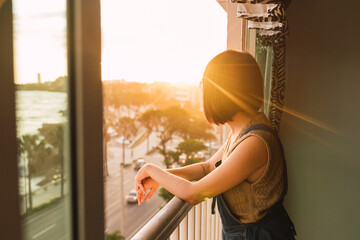 Cheerful woman leaning on balcony railing
