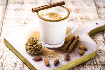 glass of eggnog prepared with liqueur, cinnamon, refined sugar, almond cream and rum, hot end-of-the-year drink