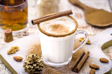 glass of eggnog prepared with liqueur, cinnamon, refined sugar, almond cream and rum, hot end-of-the-year drink