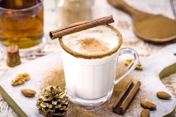 Fotobehang glass of eggnog prepared with liqueur, cinnamon, refined sugar, almond cream and rum, hot end-of-the-year drink © RHJ