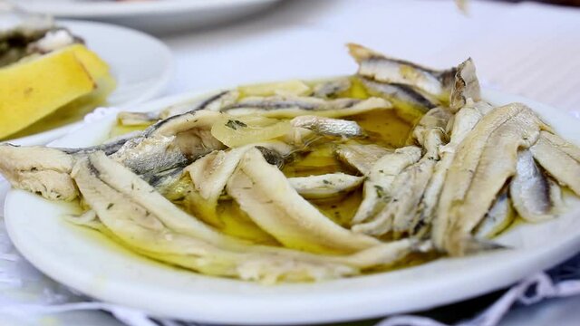 Eating fish fillet in olive oil and vinegar