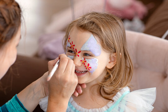 smiling happy child with face art aqua grimm on birthday or halloween party. face art painting