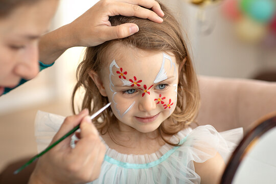 Little cute child with face art on birthday party. Face art painting. Halloween party. Children with funny face painting. Happy birthday.