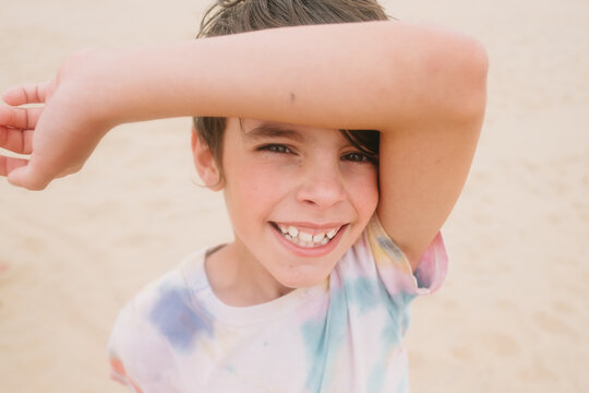 Portrait of smiling child looking at camera on sand