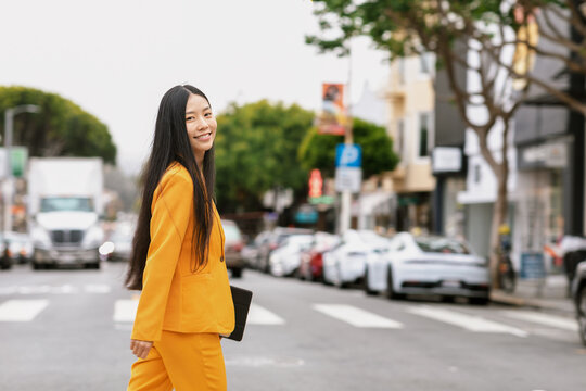 Glad Chinese woman standing near bus in city