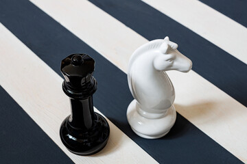 Obraz premium chess pieces on a striped black-white board. different rules