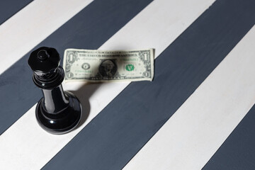 black chess piece queen casts a shadow on the dollar bill. a great threat loomed