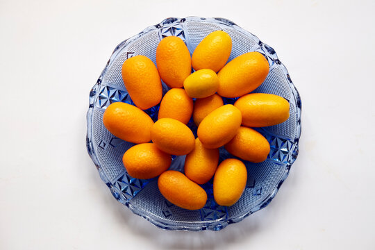 Kumquat In Blue Glass Plate