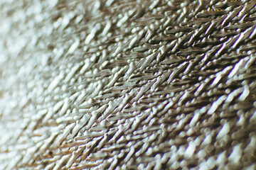 Beautiful abstract background made of material. The texture of aluminum foil. Soft focus. Macro photography.