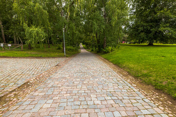 Beautiful view of park with old cobblestone pavement stone walkway background. Cobblestone pavement texture. Sweden.