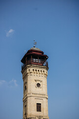 Fototapeta na wymiar An old brick fire tower. Tower against a clear blue sky