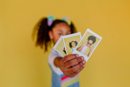 Girl holding pictures of mom and herself