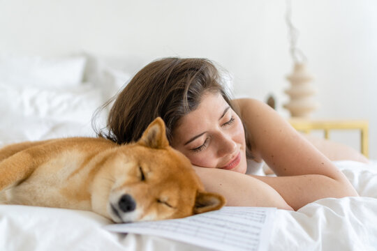 Woman and dog sleeping together in bed