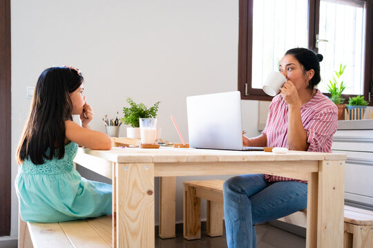 Mother having breakfast with her daughter at kitchen