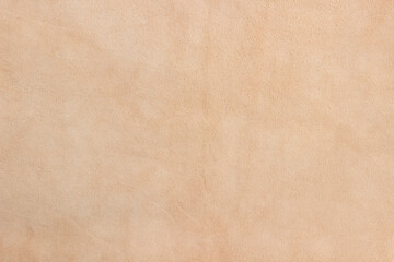 Light beige matte background of suede fabric, closeup. Velvet texture of seamless sand leather. Soft beige leather texture with print as background. - obrazy, fototapety, plakaty