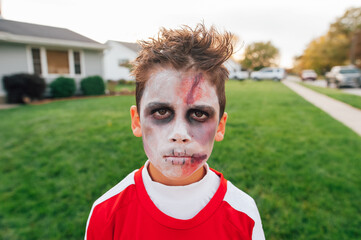 Preteen child face painted as a zombie. 