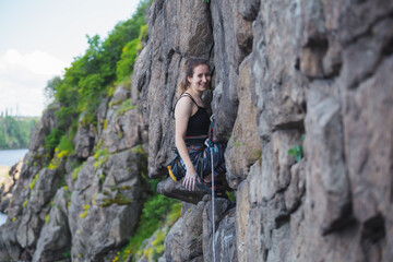 Naklejka premium A girl climbs a rock