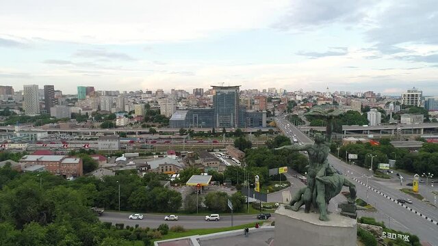 Aerial view of modern Russian city in summer. Traffic on roads, houses, trees, cars