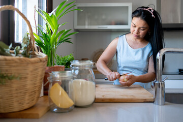 Woman peeling an onion at kitchen