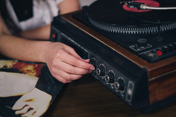 Schoolgirl adjust the sound on gramophone old player