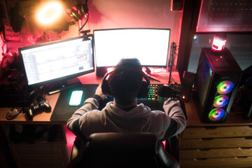 Back of a gamer in his bedroom with his setup