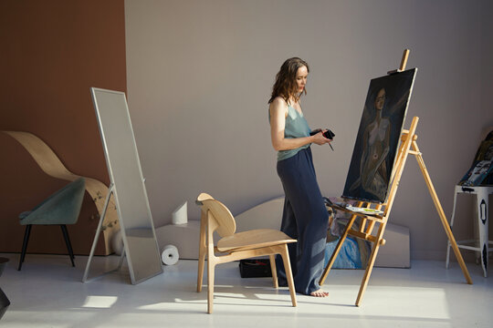 Female artist painting portrait in studio
