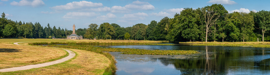 Fototapeta na wymiar Panorama of dutch national park De Hoge Veluwe with lake and the building of hunting lodge Sint Hubertus