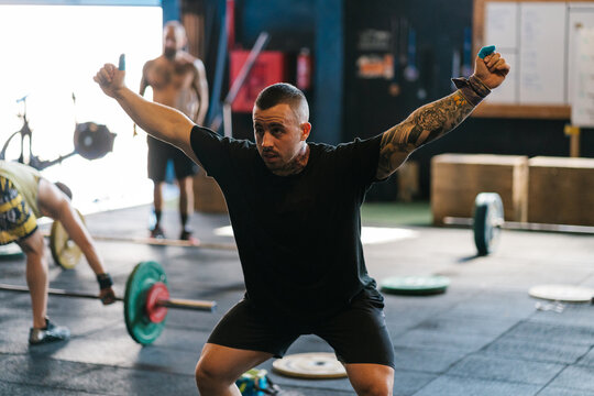Male athlete practicing snatch without barbell