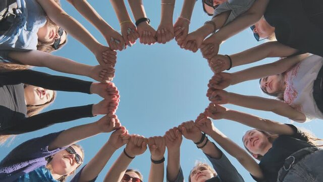 A group of girls makes a circle from their fists of their hands.