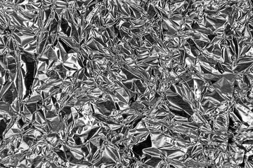 Thin sheet of silver leaf background with shiny crumpled uneven surface
