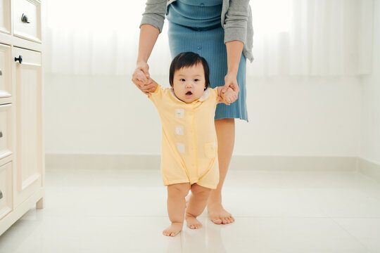 Asian baby girl taking first steps walk forward