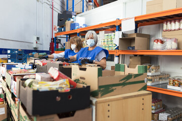 Volunteer womans preparing food packages