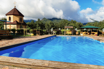A swimming pool with a church. A quiet place to relax by the pool in nature.