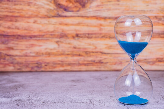 Sand falling down an hourglass - time is running - hourglass with sand, sand running through hourglass