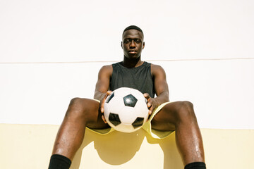 Black football player resting during training