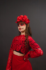 Beautiful young woman with make-up and Dia de los Muertos attire on black background.